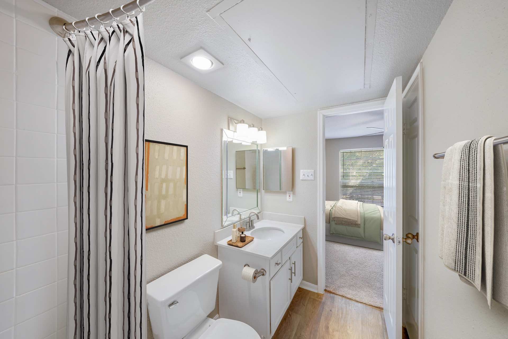 wood-style flooring and ample lighting in bathroom